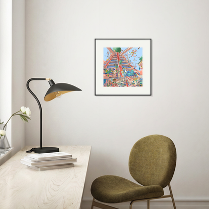 Colorful framed artwork on a wall above a desk with a lamp and chair.