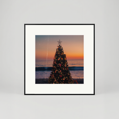 Framed artwork of a Christmas tree on a beach at sunset.