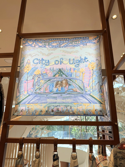 Decorative panel with 'City of Light' text and cityscape illustration, displayed on a stand.