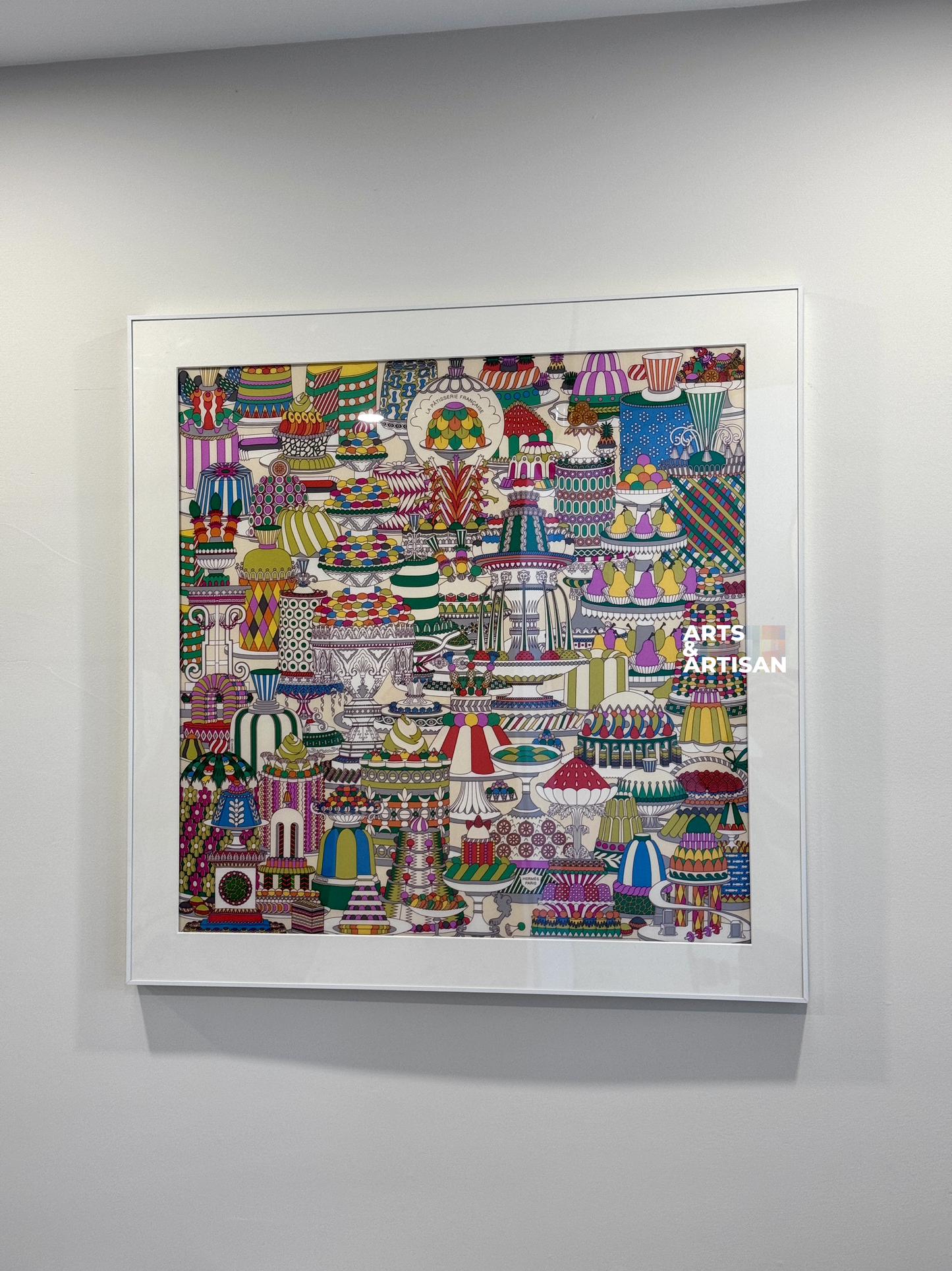 A framed square Hermes Scarf featuring a highly detailed, colorful folk-art style illustration of traditional Indian lamps (oil lamps) in a mandala pattern, mounted on a light gray wall.