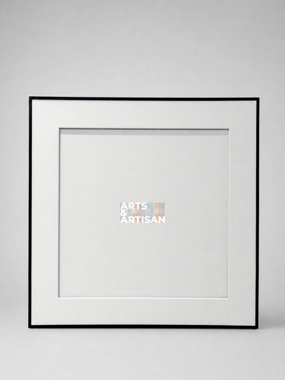 A square picture frame with a thin black border and a wide white mat, shown against a light gray background. A small Arts & Artisan logo is visible in the center of the mat.