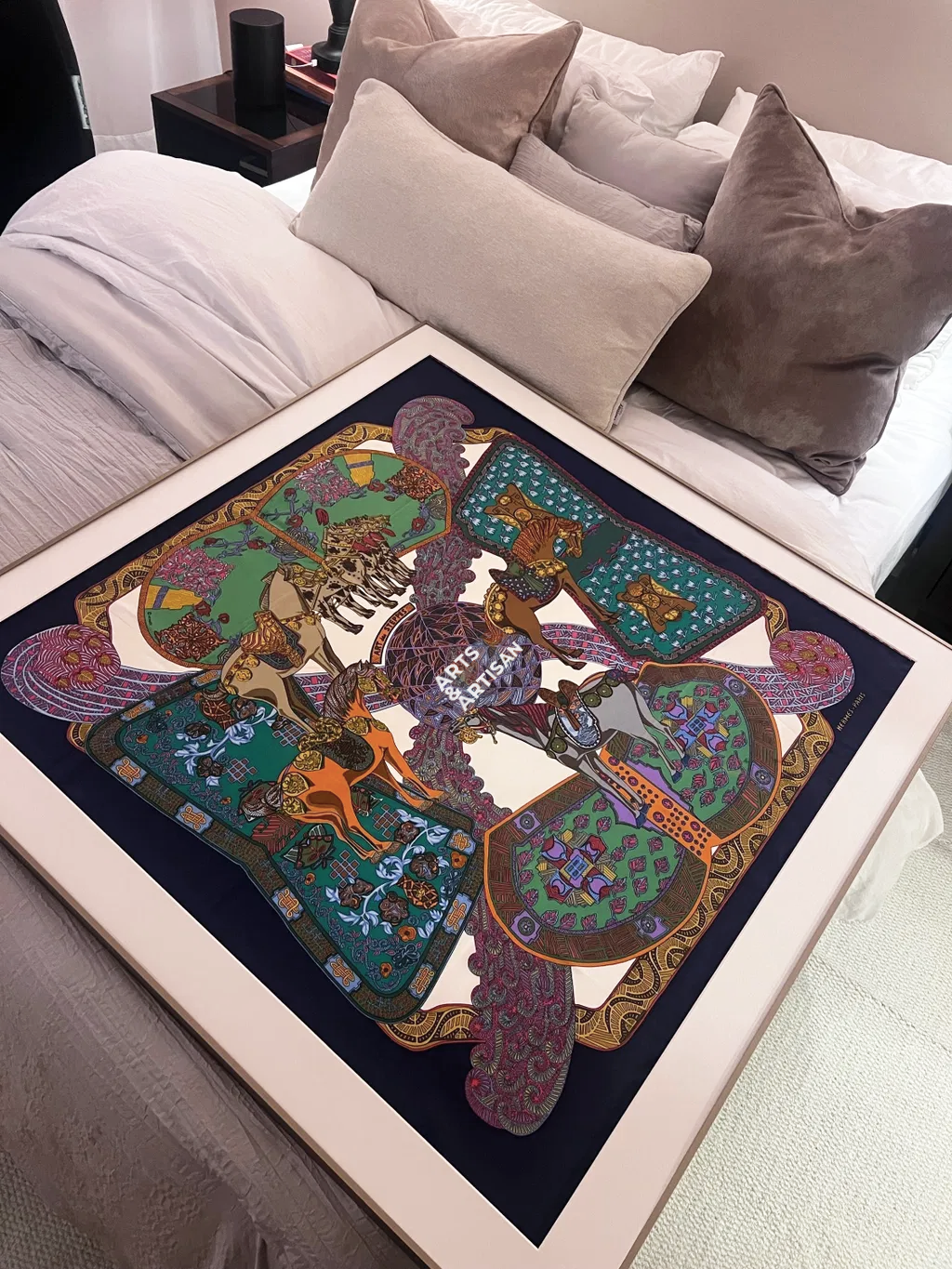 Copper Bronze Hermès scarf frame by Arts & Artisan with a framed silk scarf on a bed
